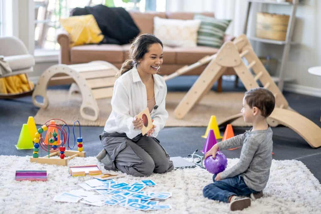 A therapist engaging with a young child in a bright, playful space filled with toys and sensory activities. This image represents Key Healthcare’s holistic and recreational therapies, emphasizing creative, play-based approaches to foster emotional well-being, build confidence, and support mental health recovery for adolescents.
