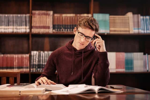 Focused teenager studying in a library, symbolizing the academic support part of Key Healthcare’s IOP